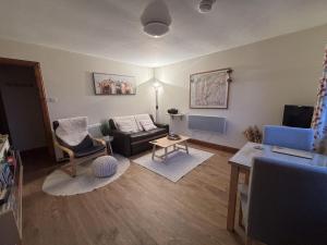 a living room with a couch and a table at Morenish Mews Killin Cottage in Morenish