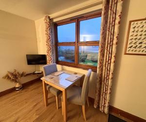 a dining room with a table and a window at Morenish Mews Killin Cottage in Morenish