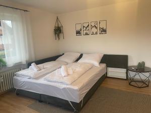 a large bed in a room with a table at Ferienwohnung Müller - Arberblick in Lohberg +6 photos