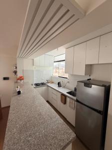 une cuisine avec des armoires blanches et un réfrigérateur en acier inoxydable dans l'établissement SB5 Apartment, à Cusco
