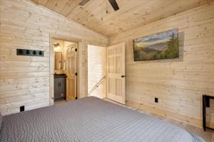 a bedroom with a bed in a wooden room at Green & Black Bear Cabins By Beyond Expectations in Sevierville