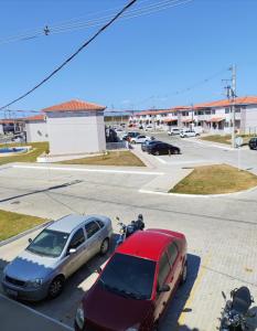two cars parked in a parking lot with a motorcycle at Refúgio Aconchegante Solares in Petrolina