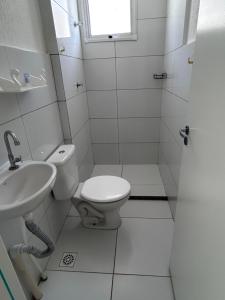 a white bathroom with a toilet and a sink at Refúgio Aconchegante Solares in Petrolina +1 photo
