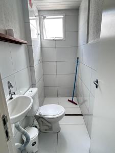 a bathroom with a toilet and a sink and a window at Refúgio Aconchegante Solares in Petrolina