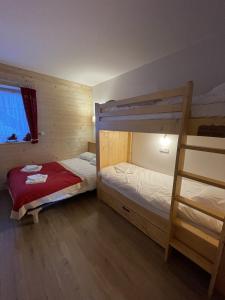 a bedroom with two bunk beds and a ladder at Chalet AIGUILLON RDC D in Le Lioran