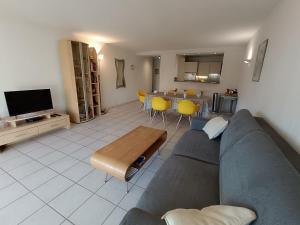 a living room with a gray couch and a table at Apartment Le Magellan-2 by Interhome in Saint-Raphaël