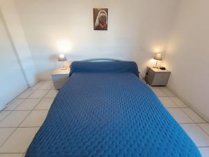 a blue bed in a small room with two lamps at Apartment Le Magellan-2 by Interhome in Saint-Raphaël +15 photos