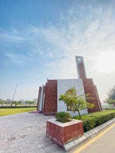 un bâtiment en briques avec une tour d'horloge en arrière-plan dans l'établissement Lower canal 1 BHK secure area, à Faisalabad 3 autres photos