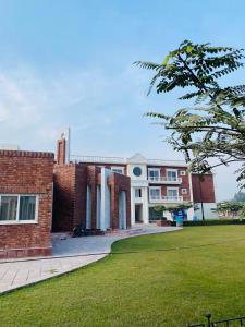 un grand bâtiment en briques avec une pelouse verte dans l'établissement Lower canal 1 BHK secure area, à Faisalabad