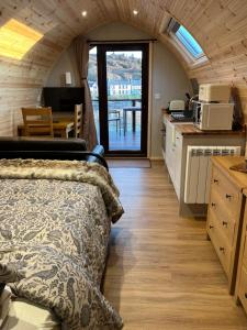 una camera da letto con un letto e una cucina con un tavolo di Inverpod a Lochinver