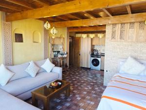 uma sala de estar com um sofá e uma mesa em Rooftop studio with ocean view em Essaouira