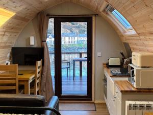 una cucina e una sala da pranzo con una porta che dà su un balcone di Inverpod a Lochinver