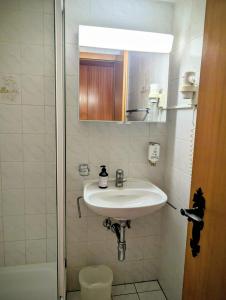 een witte badkamer met een wastafel en een douche bij Centre Thermal NORD studio TH203 in Ovronnaz