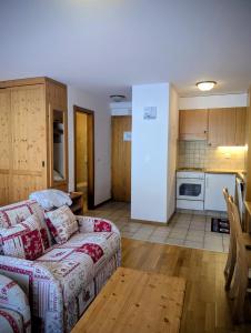 een woonkamer met een bank en een keuken bij Centre Thermal NORD studio TH203 in Ovronnaz