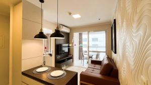 uma pequena sala de estar com um sofá e uma mesa em #2207A# Flat mobiliado no Jardim Goias em Goiânia