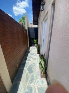 een loopbrug tussen twee gebouwen met potplanten bij Casita en general Pacheco in General Pacheco