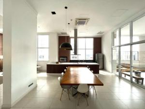 uma grande cozinha com mesa e cadeiras de madeira em #2207A# Flat mobiliado no Jardim Goias em Goiânia