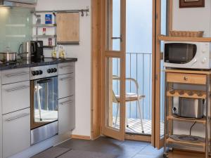 een keuken met een fornuis oven naast een balkon bij Apartment Schweizerheim Apt-5 by Interhome in Wengen +28 foto's