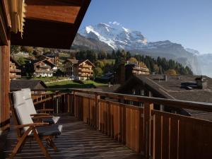 a deck with a chair and a view of a mountain at Apartment Bella Vista Apt- No- 10 by Interhome in Wengen