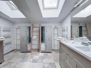a bathroom with two sinks and a skylight at Holiday Home Les Vidalières by Interhome in Saint-Sulpice-dʼArnoult
