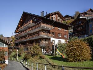 an apartment building with a playground in front of it at Apartment Bella Vista Apt- No- 10 by Interhome in Wengen