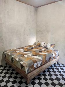 a bedroom with a bed and a checkered floor at Local Garden Homestay in Masbagik