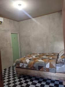a bedroom with a bed and a checkered floor at Local Garden Homestay in Masbagik +16 photos