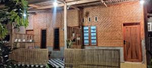 a room with brick walls and wooden doors at Local Garden Homestay in Masbagik