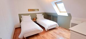 nid'Opale maison cosy à 3 minutes des plages في ويميريوكس: سريرين في غرفة صغيرة بها نافذة