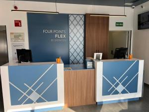an office with two reception desks and a sign that reads four points flex at Flex Malaga City Center in Málaga
