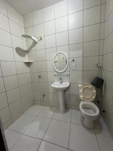 a white bathroom with a toilet and a sink at Pousada Rosa Mistica in Paracuru +20 photos