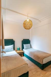 Un dormitorio con dos camas y una lámpara de araña. en Suite Elegante 2 chambres Confort & Style Marrakech, en Oulad Akkou