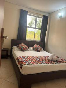 a bed in a room with a window at Hotel Tierra Santa Santa Fe de Antioquia in Santa Fe de Antioquia +19 photos