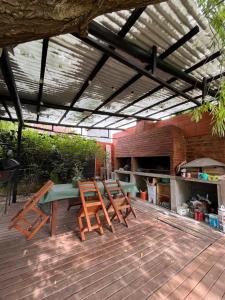 een terras met een tafel en stoelen en een barbecue bij Del Mar in Mar de Ajó