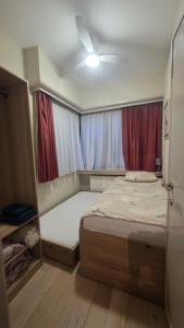 a small bedroom with a bed and curtains at Charmante appartement in Wilrijk in Antwerp