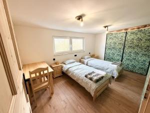 Dom Łowcy : غرفة نوم بسريرين ومكتب ونافذة