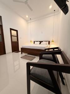 a bedroom with two beds and a chair in it at Luxury Living Villas in Matara