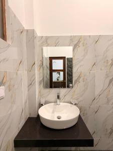 a bathroom with a white sink and a mirror at Luxury Living Villas in Matara