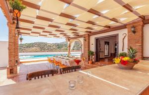 a dining room with a table and a swimming pool at Villa el Cortijo in Torrox