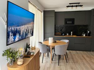 een keuken en eetkamer met een grote tv aan de muur bij Mountain Place to Remember - River & Barbecue in Buşteni
