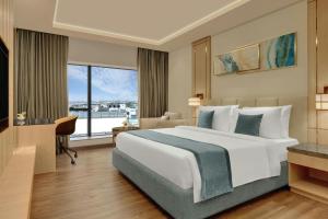 Un dormitorio con una cama grande y una ventana grande. en The Fern Residency Bengaluru, Seshadripuram, Series by Marriott, en Bangalore