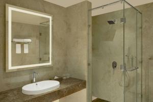 un baño con lavabo y ducha en The Fern Residency Bengaluru, Seshadripuram, Series by Marriott, en Bangalore 11 fotos más