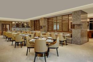 un restaurante con mesas y sillas en una biblioteca en The Fern Residency Bengaluru, Seshadripuram, Series by Marriott, en Bangalore