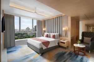 a hotel room with a bed and a chair at The Fern Residency Mumbai, Mira Road, Series by Marriott in Mumbai