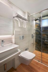 a bathroom with a toilet and a sink and a shower at The Fern Residency Mumbai, Mira Road, Series by Marriott in Mumbai