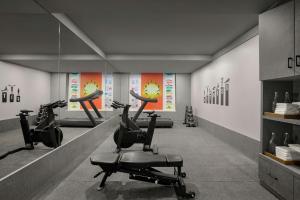 a gym with treadmills and exercise bikes in a room at The Fern Residency, Solapur, Series by Marriott in Solapur
