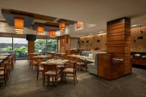 a restaurant with tables and chairs in a room at The Fern, Jaipur, Series by Marriott in Jaipur