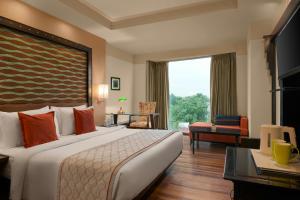 a hotel room with a bed and a large window at The Fern, Jaipur, Series by Marriott in Jaipur +18 photos