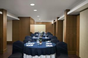 a conference room with tables and blue chairs at The Fern Residency Woodland, Pune, Series by Marriott in Pune