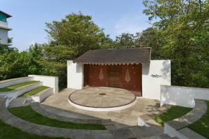 a garden with a small building with a fountain at The Fern Samali Resort Dapoli, Series by Marriott in Dapoli